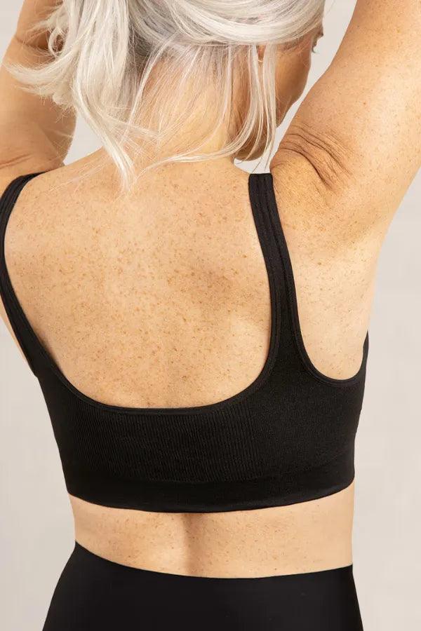 Costas de mulher madura com top esportivo preto, conforto, moda fitness, cabelo grisalho