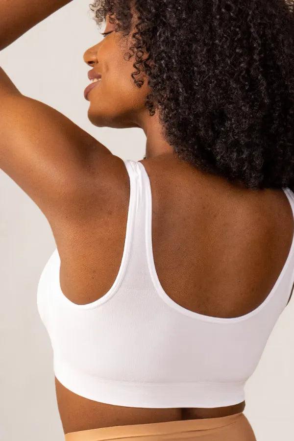 Mulher vestindo top branco de alças largas, vista de costas, moda fitness feminina.
