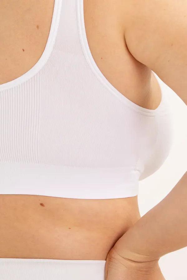 Top esportivo feminino branco em tecido canelado, detalhe lateral no corpo