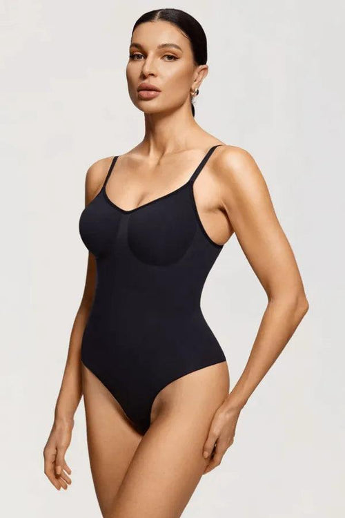 Modelo vestindo body modelador preto com alças finas em fundo neutro
